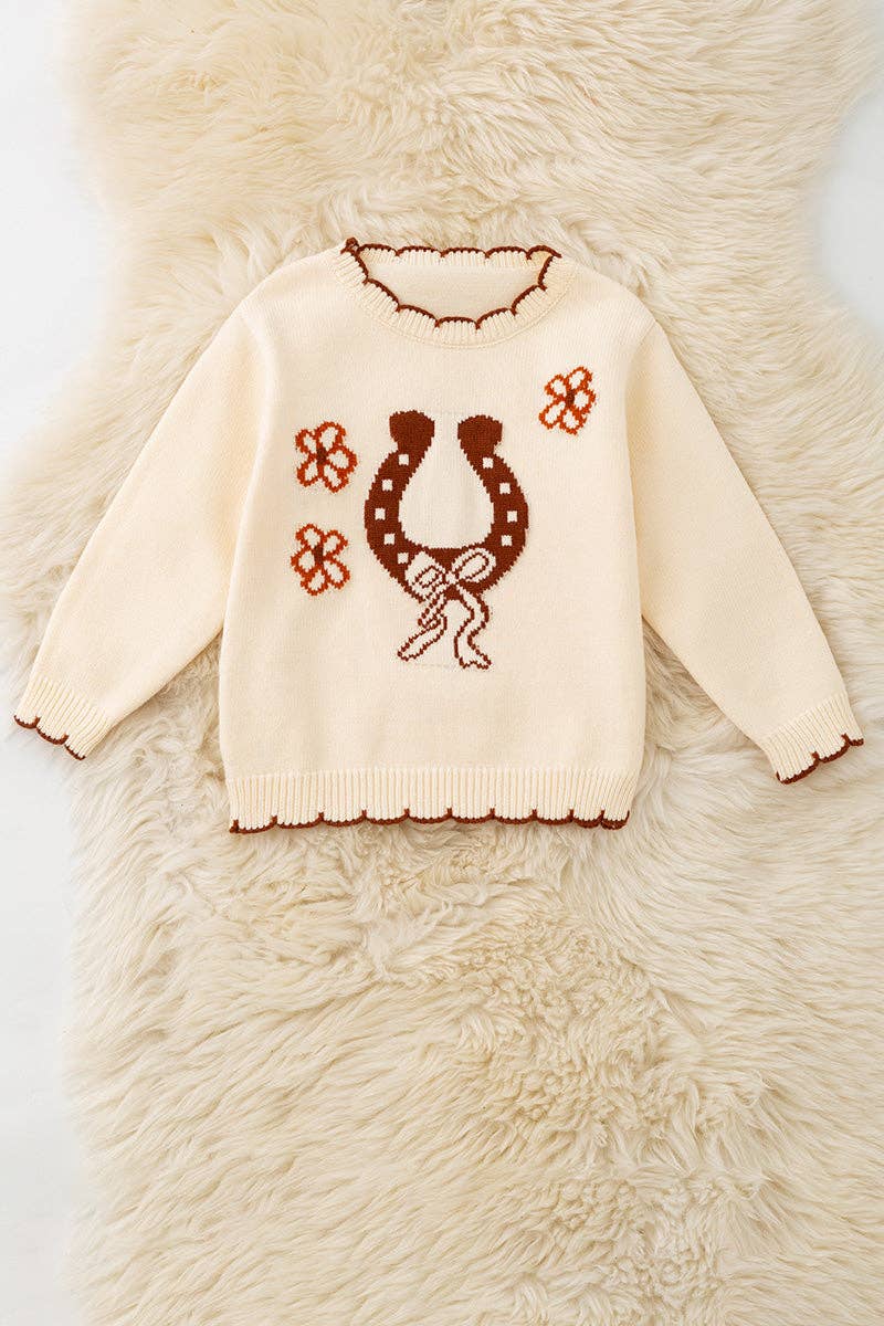 Horse shoe on cream knot pullover sweater w/moon stitch.